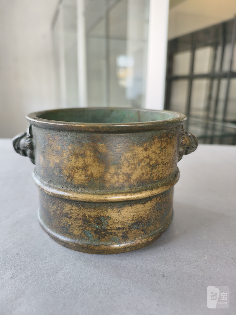 A cylindrical bronze incense burner in the shape of a cylindrical 'Lian' with relief burrs and mask handles on the sides - 图9